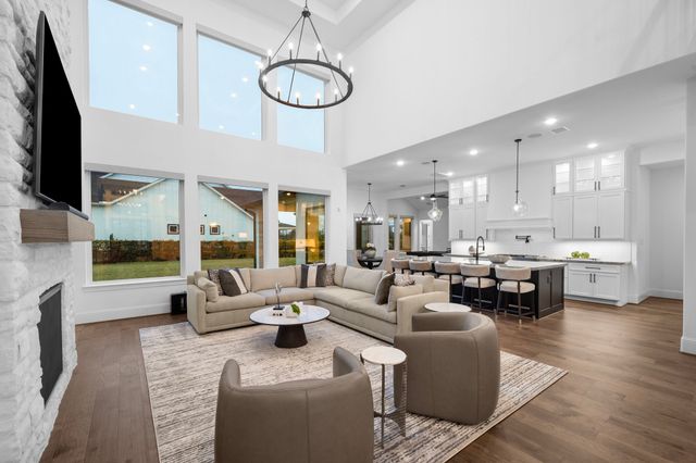 a living room with furniture a flat screen tv and kitchen view