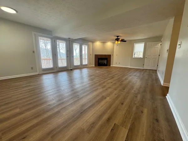a view of empty room with wooden floor and fireplace