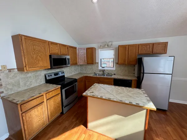 a kitchen with wooden cabinets and refrigerator