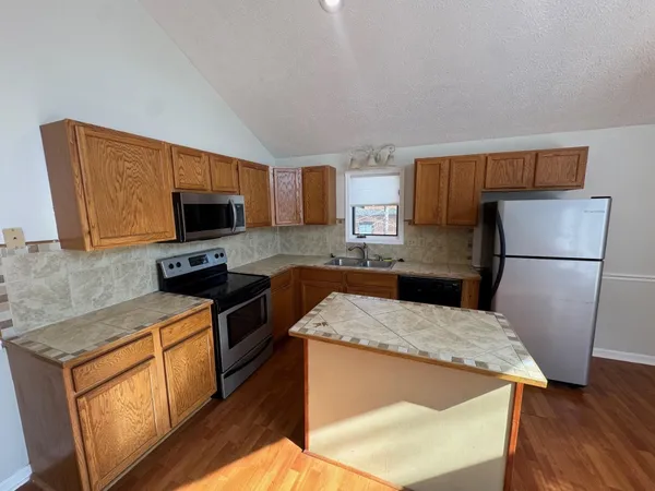 a kitchen with wooden cabinets and refrigerator
