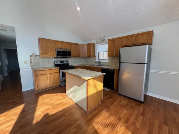 a kitchen with stainless steel appliances granite countertop a refrigerator a stove a sink and a microwave