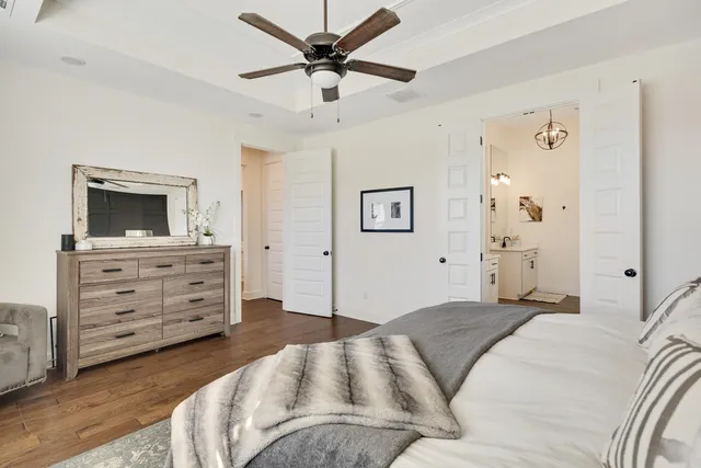 a bedroom with a large bed chandelier and a window