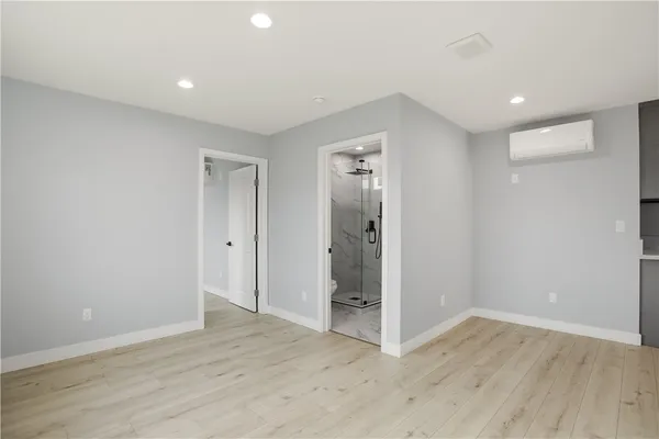 a view of an empty room with wooden floor and closet