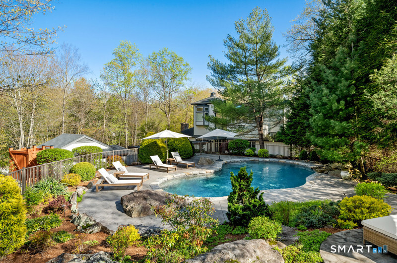 30 Catbrier Road Weston, CT 06883 - Photo 25 of 26 a view of a garden with lawn chairs under an umbrella