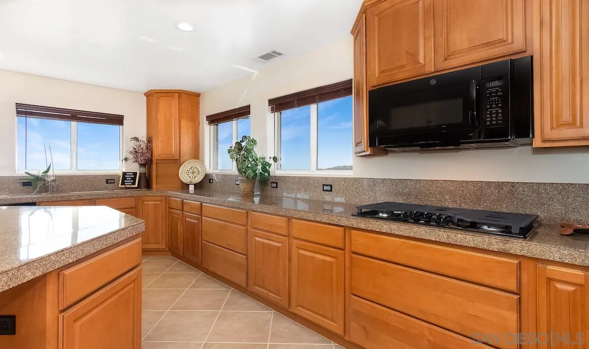 12951 Rancho Heights Road Pala, CA 92059 - Photo 11 of 41 a kitchen with stainless steel appliances granite countertop a sink and a stove top oven with granite countertops
