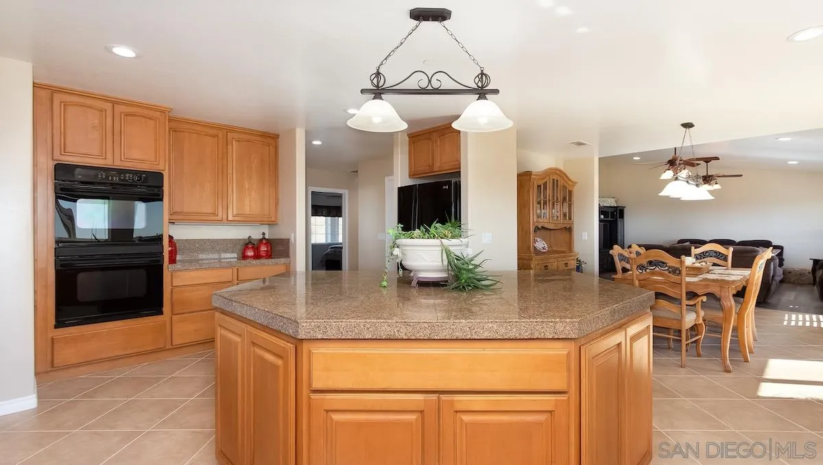 12951 Rancho Heights Road Pala, CA 92059 - Photo 8 of 41 a kitchen with stainless steel appliances granite countertop a sink refrigerator and cabinets