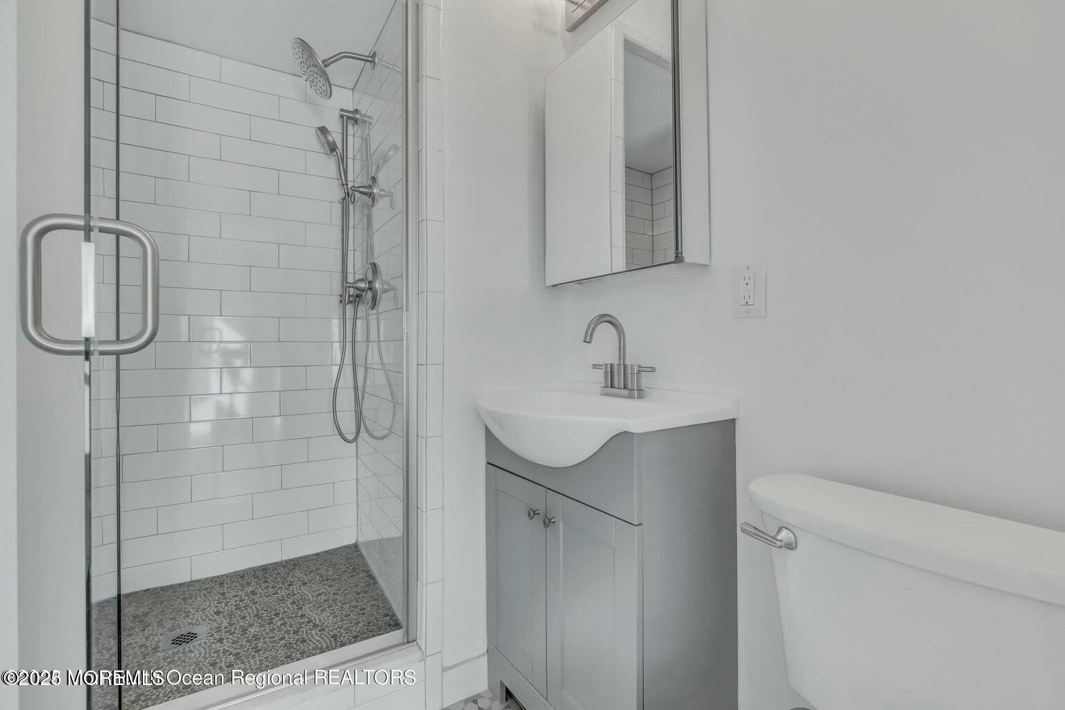 28 Riverside Avenue, Unit 1G Red Bank, NJ 07701 - Photo 13 of 25 a bathroom with a shower sink and mirror