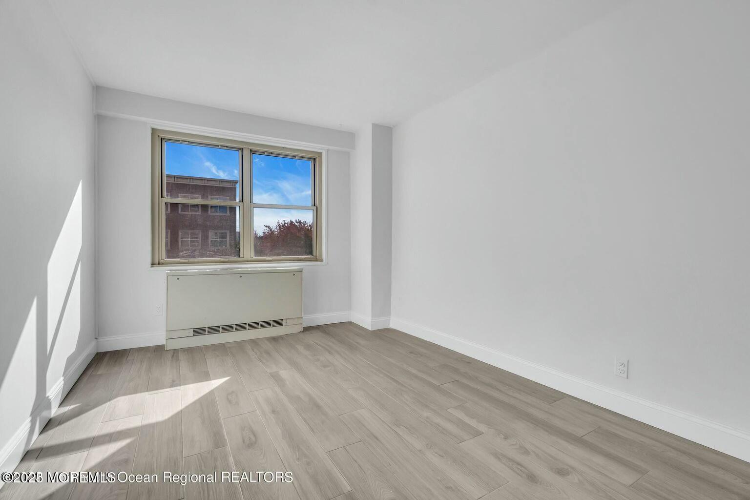 28 Riverside Avenue, Unit 1G Red Bank, NJ 07701 - Photo 14 of 25 an empty room with wooden floor and windows
