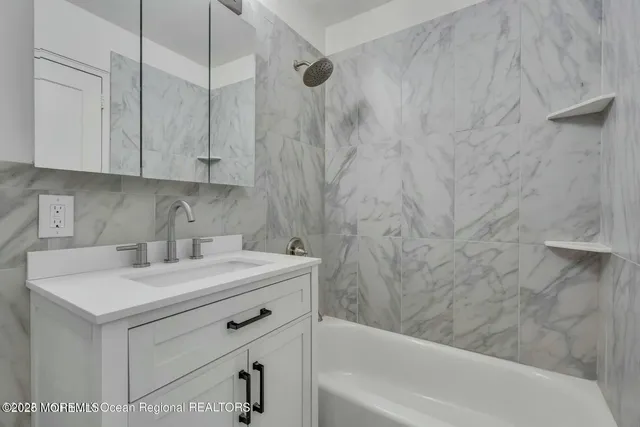 a bathroom with a sink a vanity and a bathtub