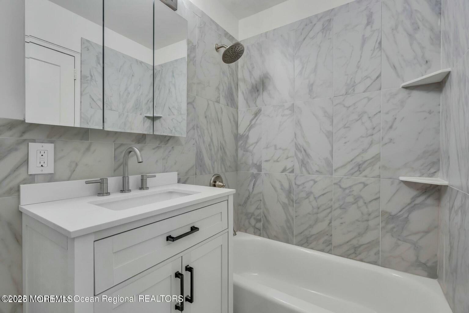 28 Riverside Avenue, Unit 1G Red Bank, NJ 07701 - Photo 16 of 25 a bathroom with a sink a vanity and a bathtub