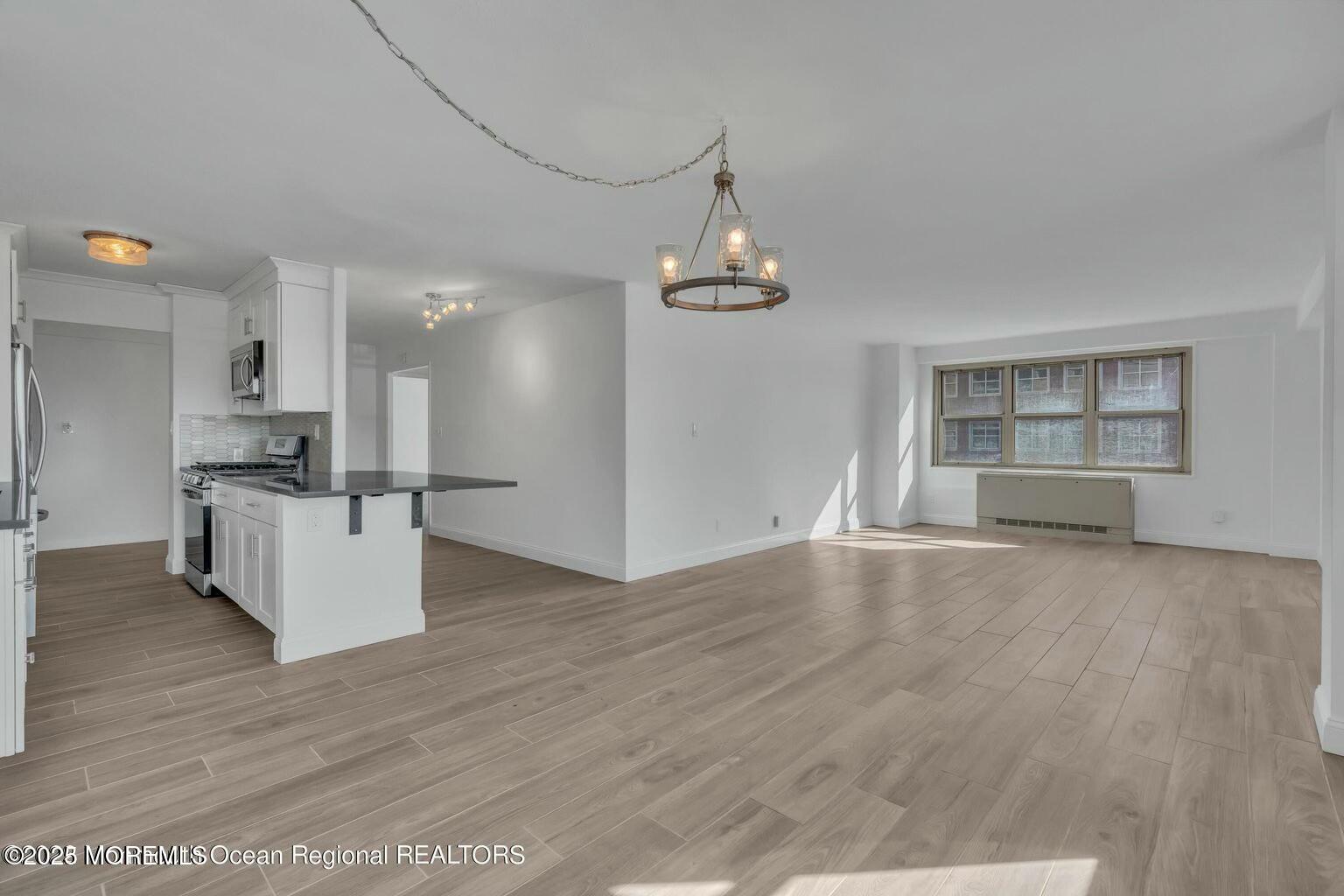 28 Riverside Avenue, Unit 1G Red Bank, NJ 07701 - Photo 2 of 25 a view of a kitchen with furniture and wooden floor