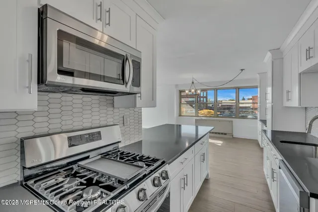 a kitchen with stainless steel appliances a stove a microwave and cabinets