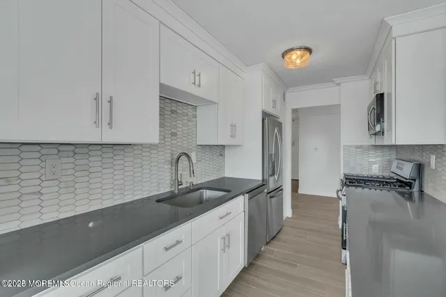 a kitchen with stainless steel appliances granite countertop a sink stove and cabinets