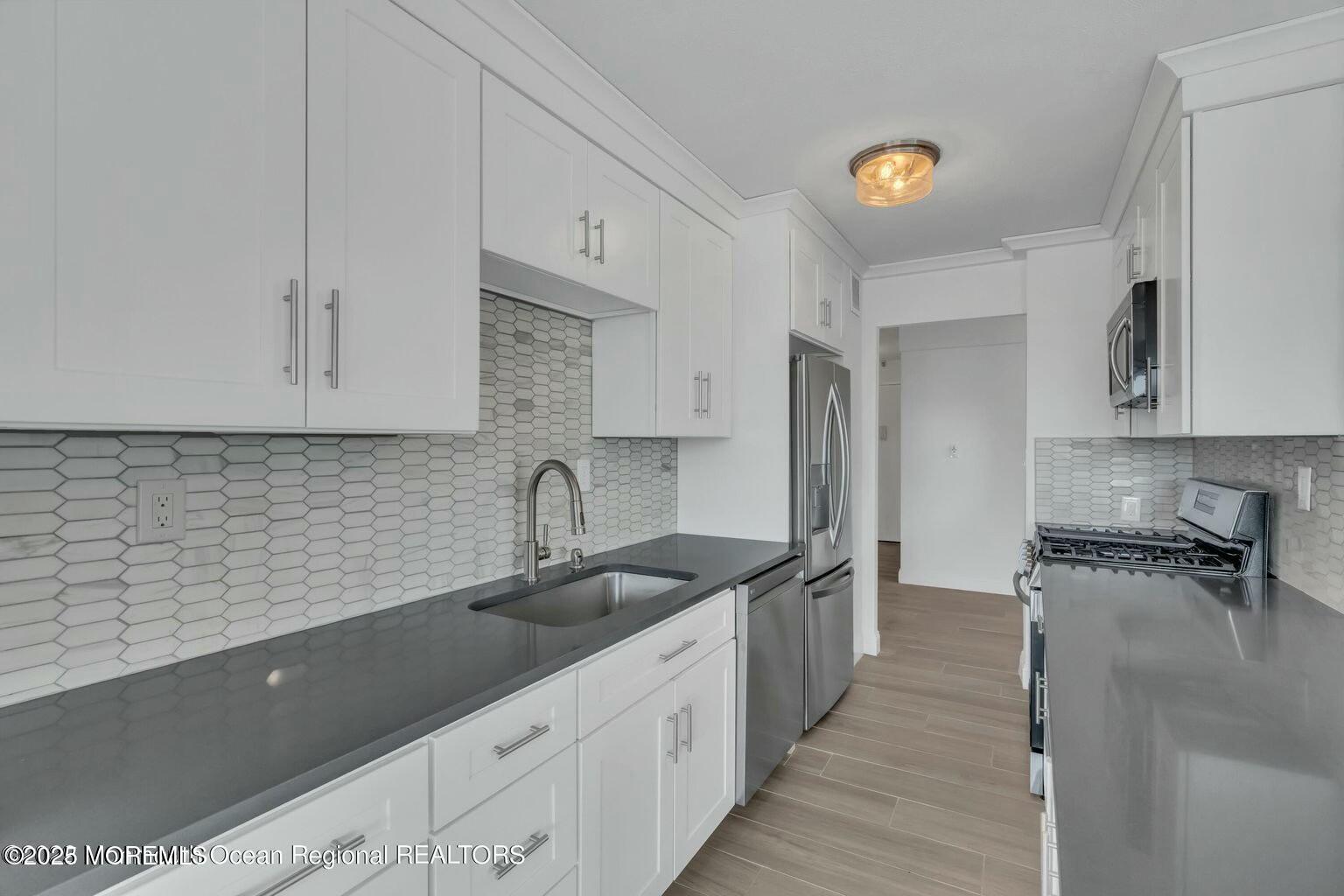 28 Riverside Avenue, Unit 1G Red Bank, NJ 07701 - Photo 7 of 25 a kitchen with stainless steel appliances granite countertop a sink stove and cabinets