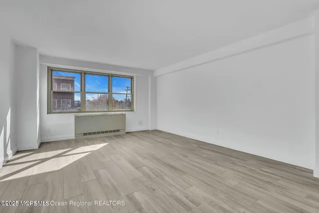 a view of a kitchen with wooden floor and a front door
