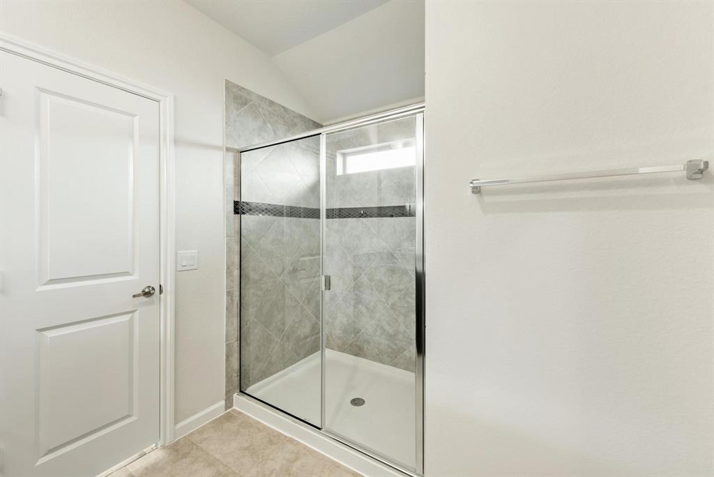 920 Elk Ridge Run Godley, TX 76044 - Photo 24 of 34 Shower enclosure with glass sliding door and light gray tile surround