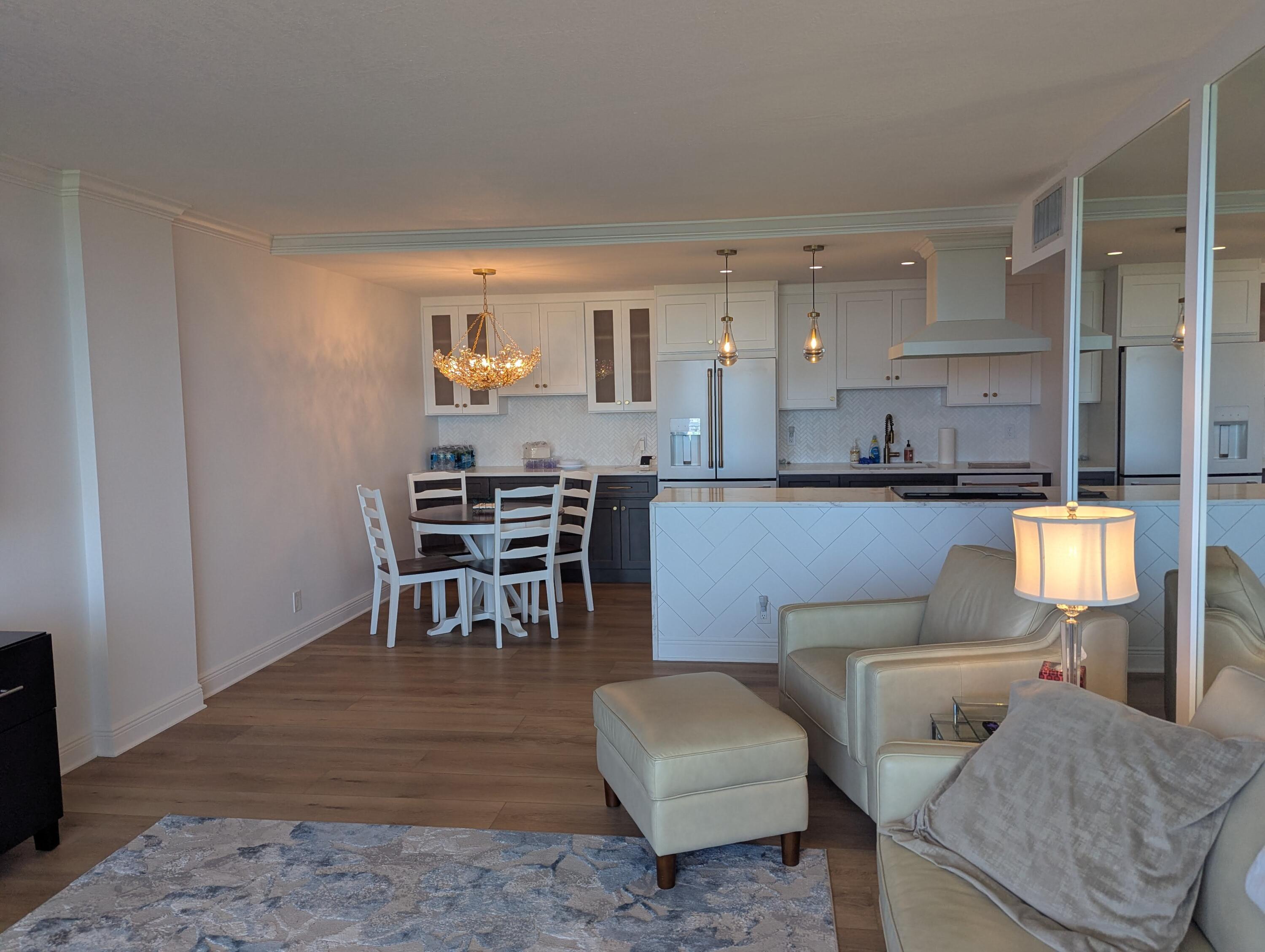 2121 North Ocean Boulevard, Unit 1006E Boca Raton, FL 33431 - Photo 12 of 64 a living room with furniture and a dining table with wooden floor
