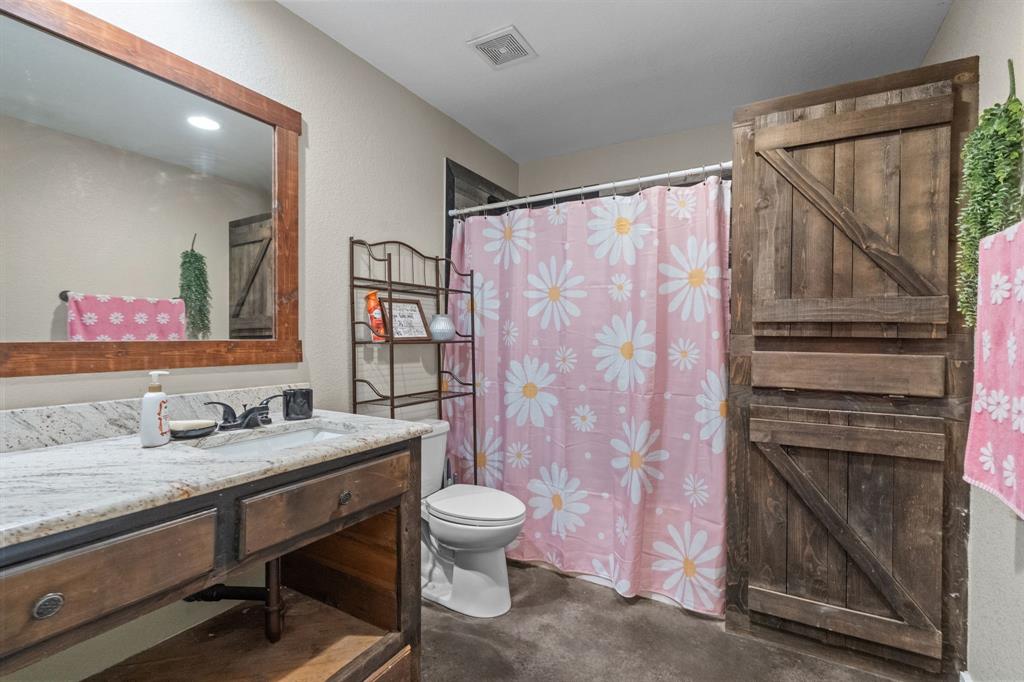 395 Private Road 4219 Decatur, TX 76234 - Photo 26 of 29 a bathroom with a granite countertop sink a toilet a shower and a mirror