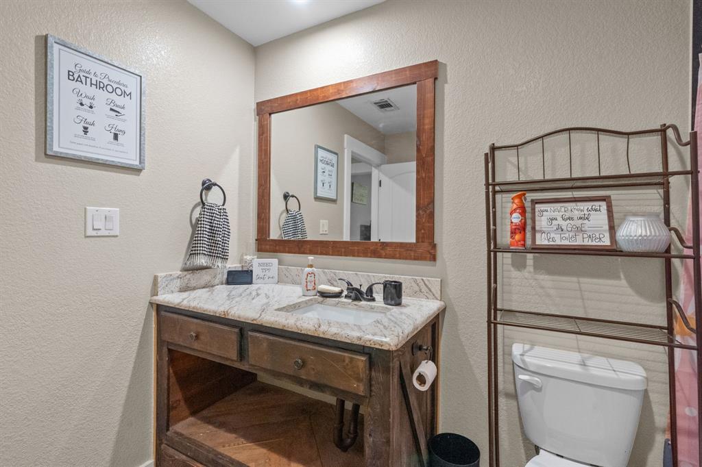 395 Private Road 4219 Decatur, TX 76234 - Photo 27 of 29 a bathroom with a toilet sink and mirror