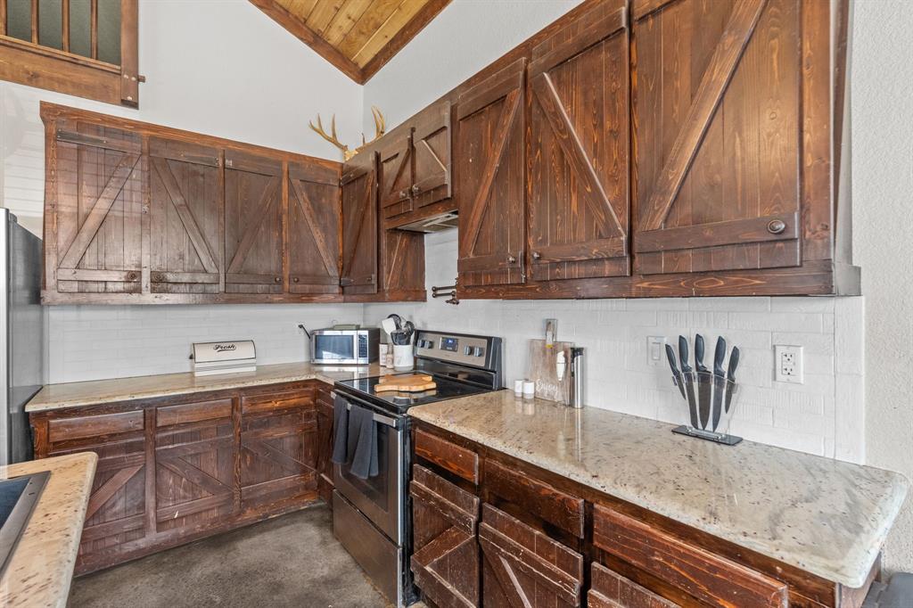 395 Private Road 4219 Decatur, TX 76234 - Photo 10 of 29 a kitchen with stainless steel appliances granite countertop a sink a stove and a microwave oven