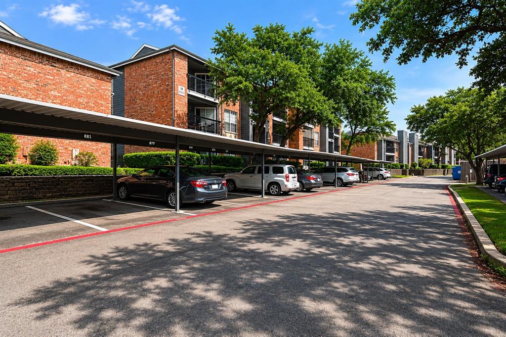 18333 Roehampton Drive, Unit 1036 Dallas, TX 75252 - Photo 10 of 12 Covered parking structures providing shade, visible alongside multi-story residential buildings featuring brick and siding exteriors