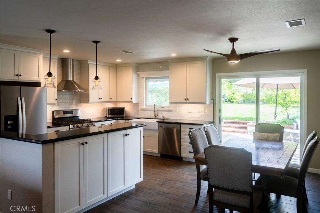 4125 Tranquilla Avenue Atascadero, CA 93422 - Photo 6 of 27 a kitchen with stainless steel appliances granite countertop a stove a sink a refrigerator a dining table and chairs
