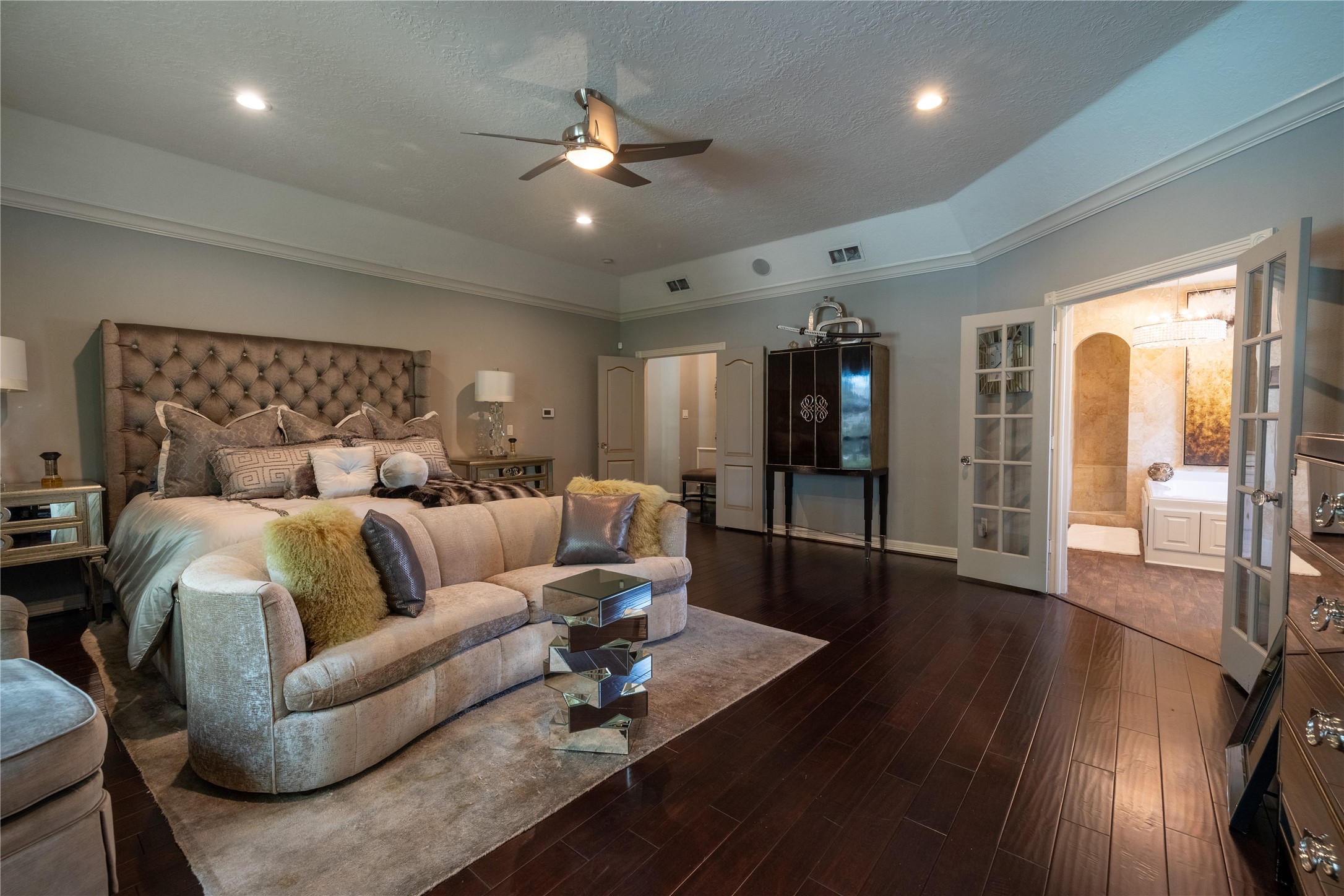 4002 Silver Ridge Boulevard Missouri City, TX 77459 - Photo 19 of 50 This spacious Primary Bedroom features elegant dark wood flooring, a cozy sitting area, and direct access to an ensuite bathroom with walk-through shower and a separate tub.