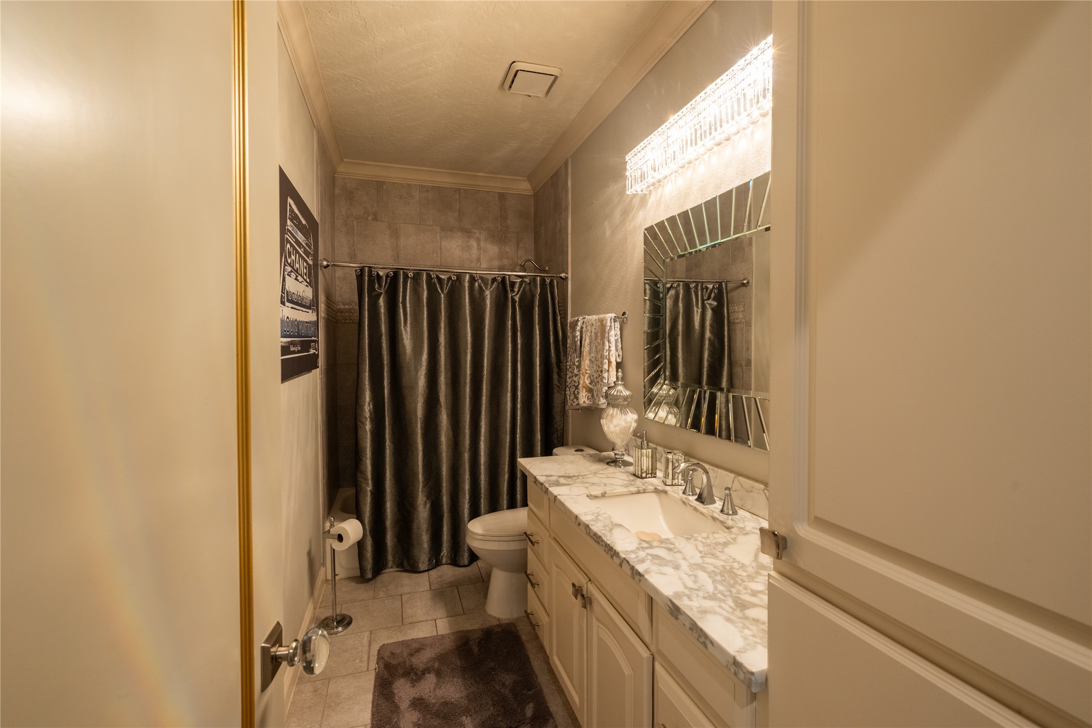 4002 Silver Ridge Boulevard Missouri City, TX 77459 - Photo 22 of 50 This is a compact, well-appointed bathroom with a shower, toilet, and vanity with ample countertop space. The decor includes elegant fixtures and a sophisticated color scheme.