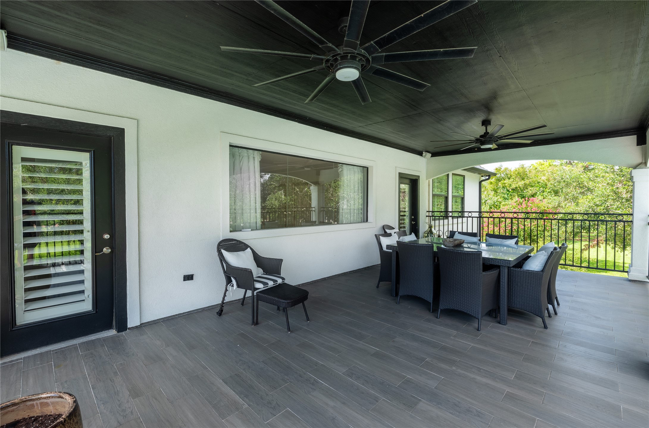 4002 Silver Ridge Boulevard Missouri City, TX 77459 - Photo 29 of 50 This is a spacious, covered outdoor patio with ceiling fans, modern flooring, and a dining area, overlooking a green backyard. Perfect for entertaining or relaxing.