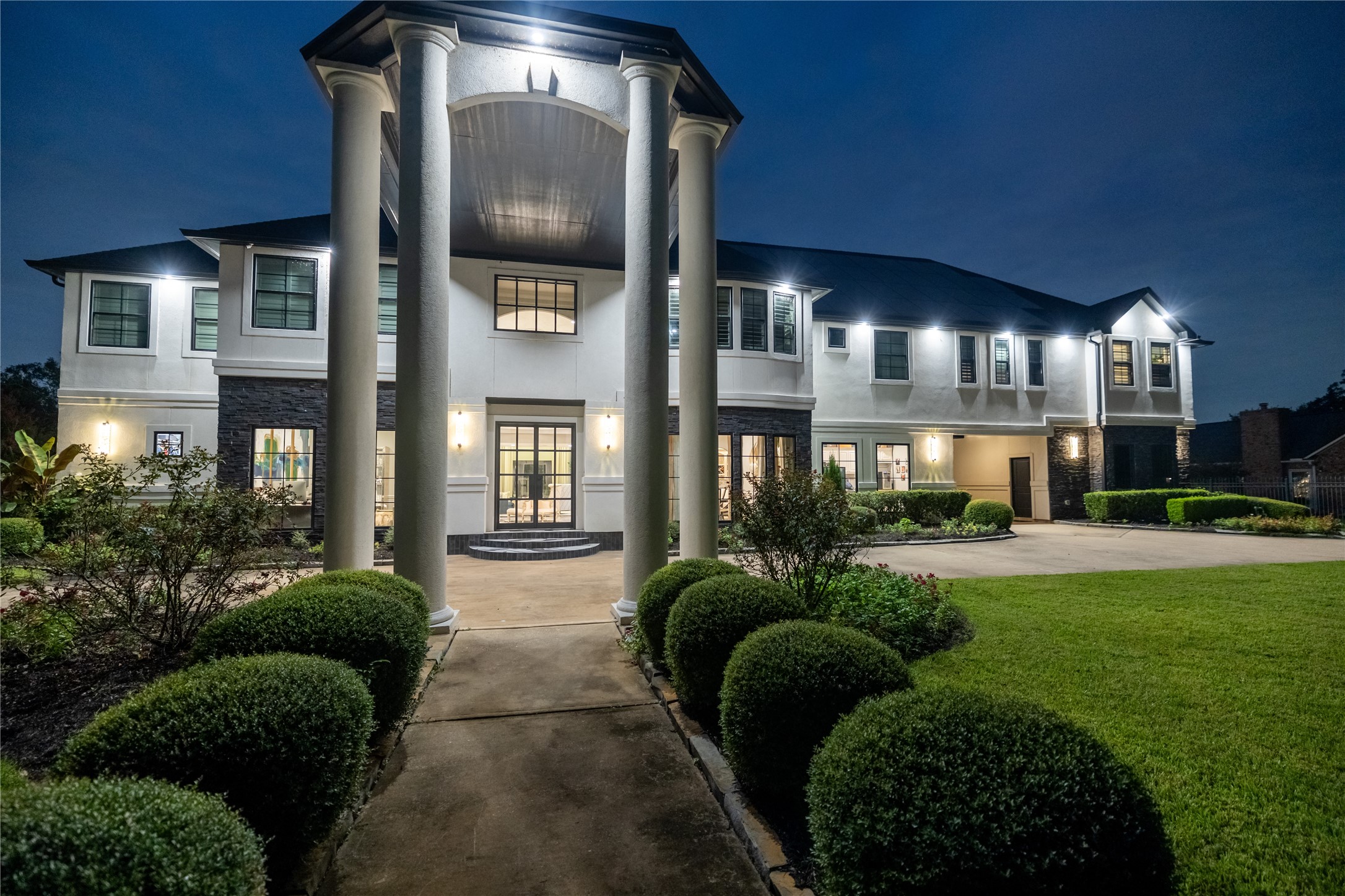 4002 Silver Ridge Boulevard Missouri City, TX 77459 - Photo 50 of 50 You're looking at an elegant two-story home featuring a grand entrance with towering columns, a mix of stucco and stone exterior, numerous large windows for ample natural light, and a well-maintained landscape. The property exudes modern luxury with a touch of classic design.