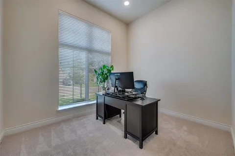 a view of a workspace with furniture and a window