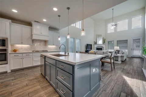 a kitchen with stainless steel appliances granite countertop a lot of counter space and wooden floors