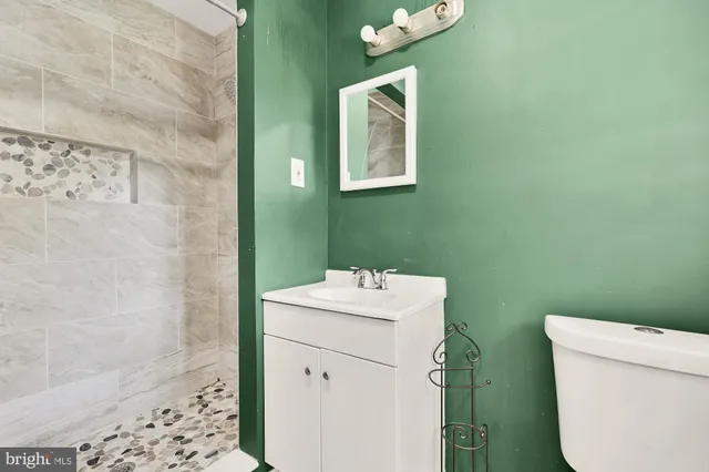 a bathroom with a sink mirror vanity and toilet