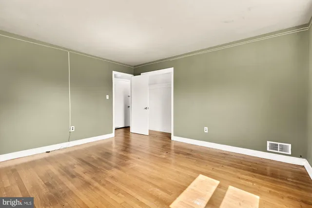 a view of an empty room with wooden floor