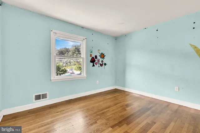 a view of a room with wooden floor and window