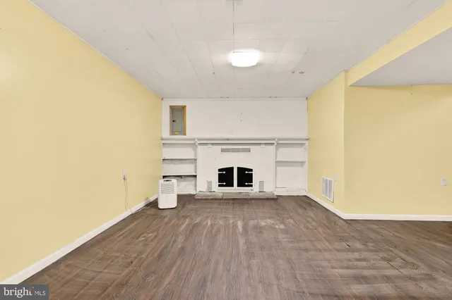 a view of a room with wooden floor and a fireplace