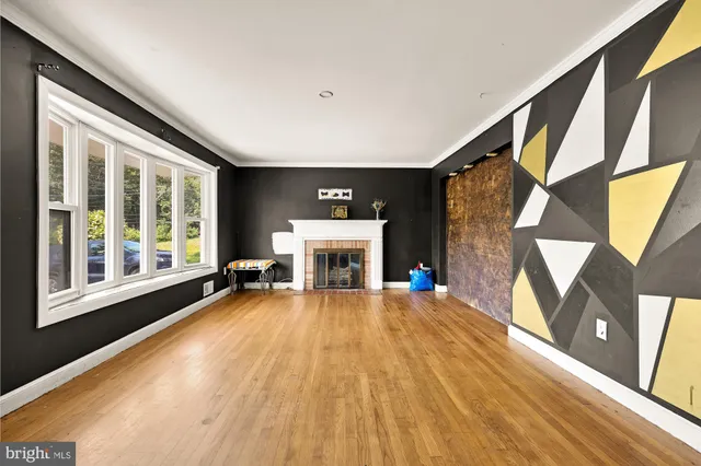 a view of a livingroom with wooden floor and a fireplace