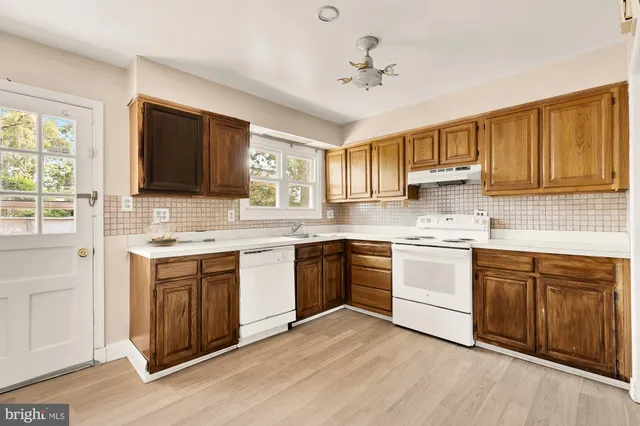 a kitchen with stainless steel appliances white cabinets a sink and a stove