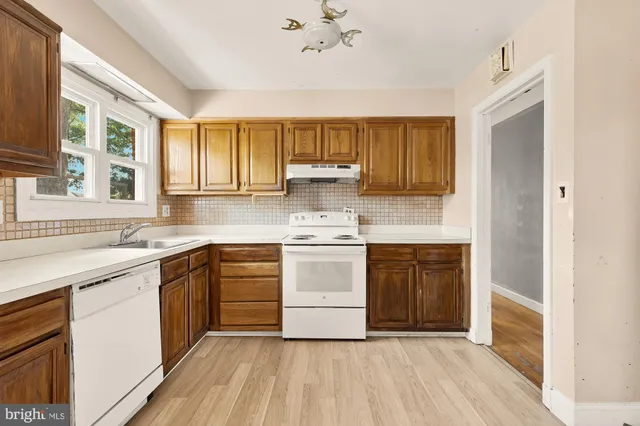 a kitchen with a white cabinets appliances and a window