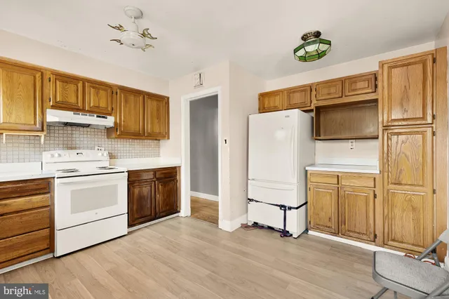 a kitchen with a refrigerator cabinets and wooden floor