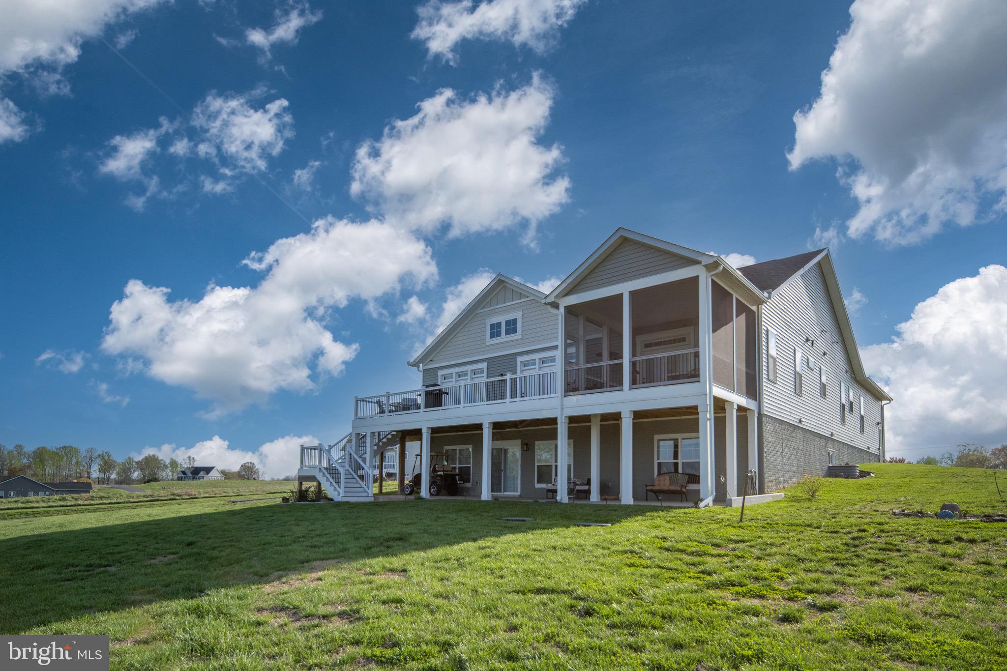 a view of a house with a big yard and large trees