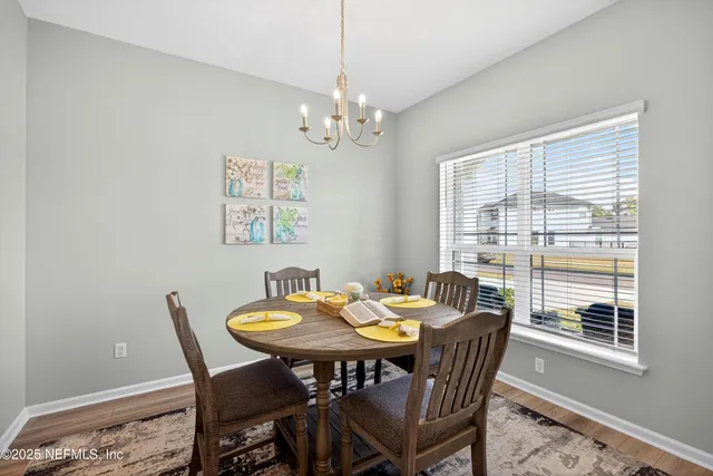 a kitchen with a refrigerator a stove and white cabinets with wooden floor