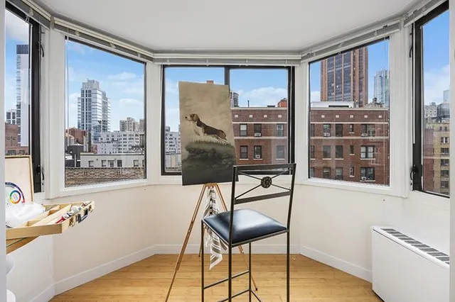 a view of a workspace with furniture and a window