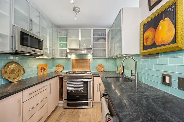 a kitchen with stainless steel appliances granite countertop a stove a sink and a microwave