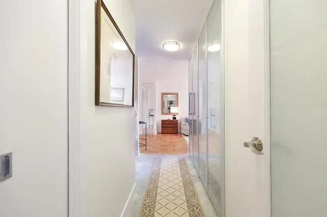 a view of a hallway with a livingroom and a bathroom with sink