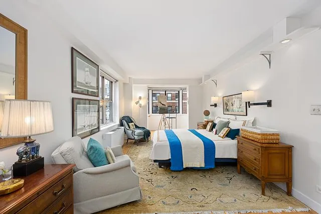 a spacious bedroom with two beds and a lamp