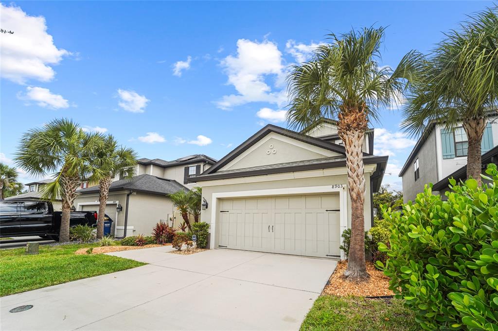 8903 Arabella Lane Seminole, FL 33777 - Photo 45 of 47 a front view of a house with a yard and garage