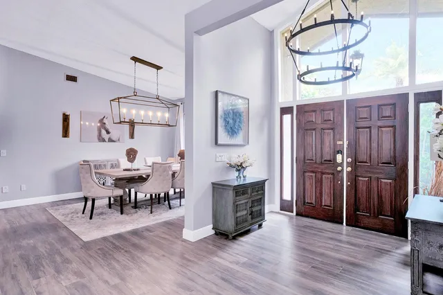 a living room with furniture chandelier and a mirror