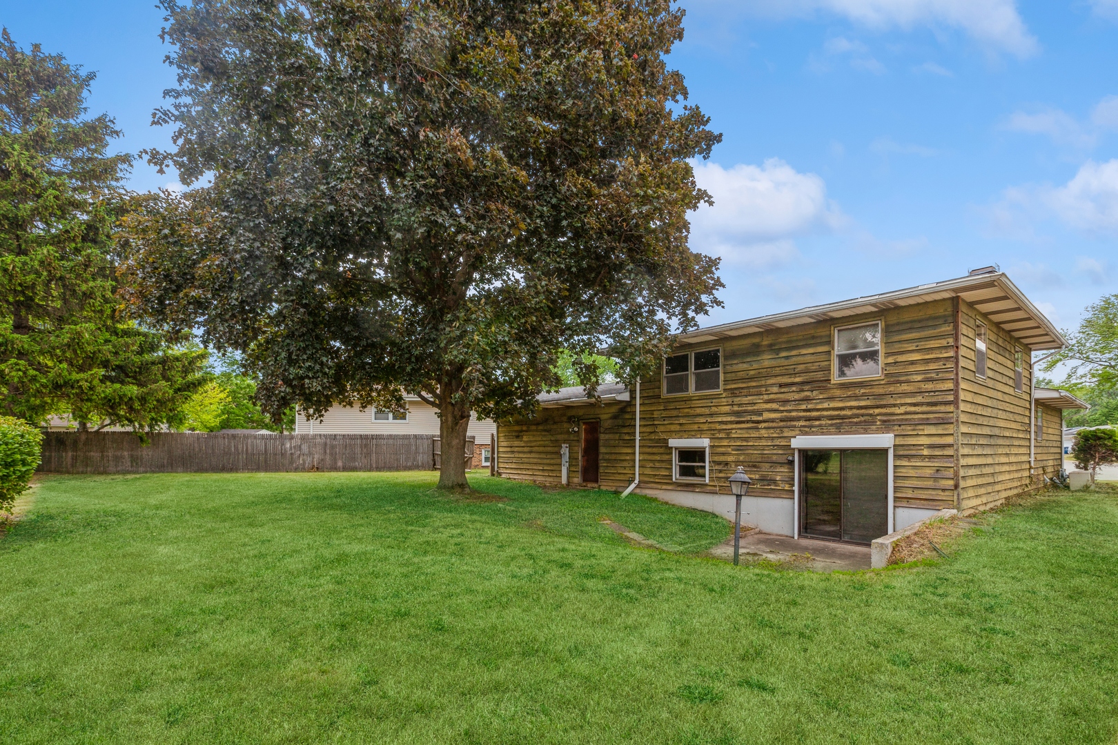 1205 Comet Drive Aurora, IL 60505 - Photo 14 of 15 a view of a backyard with a large tree