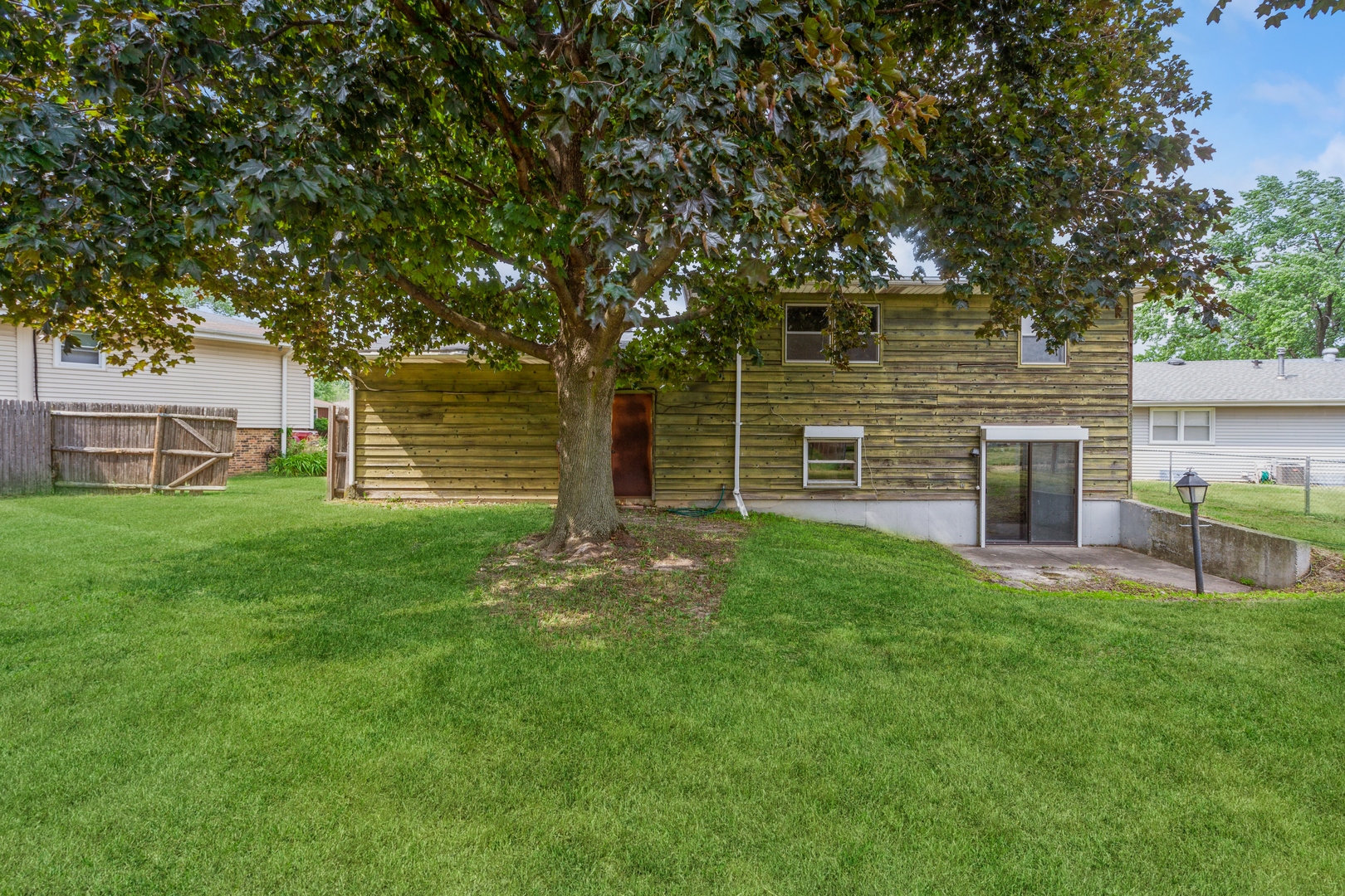 1205 Comet Drive Aurora, IL 60505 - Photo 15 of 15 a view of a backyard with table and chairs and large trees